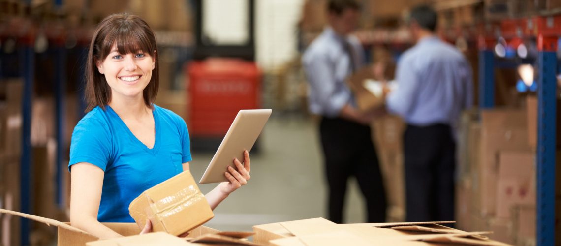 Worker In Warehouse Checking Boxes Using Digital Tablet